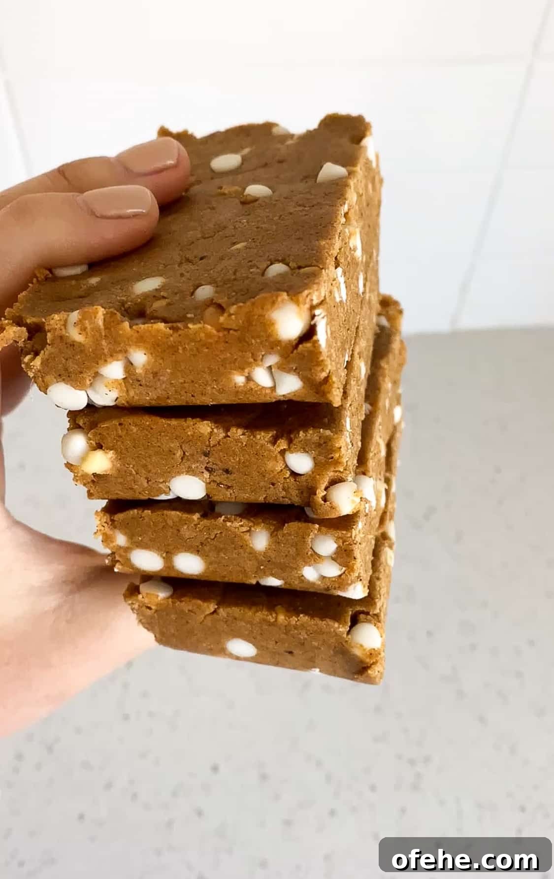 Copycat Pumpkin Protein Bars Recipe 3 side angle of pumpkin pie protein bars in between fingers