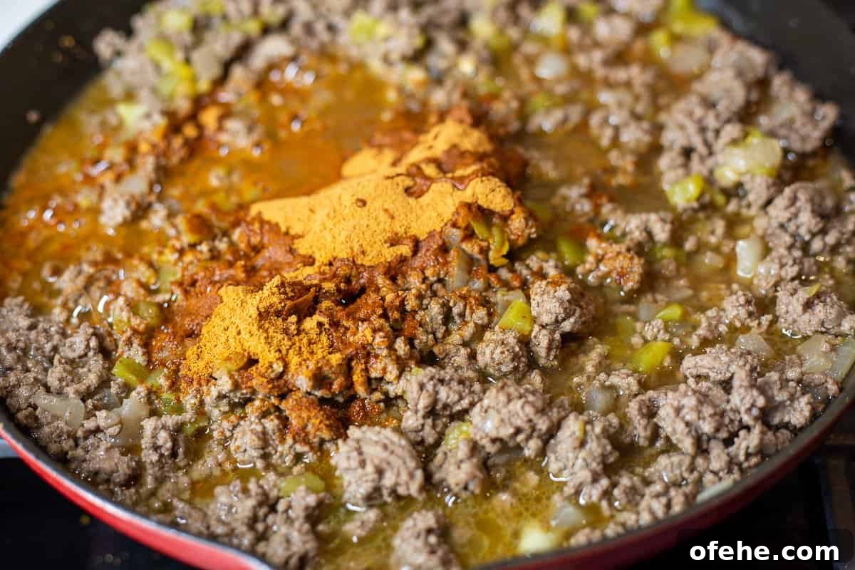 Crunchy Frito Taco Casserole with Melted Cheese and Beef 5 Ground beef, taco seasoning and chiles in skillet.