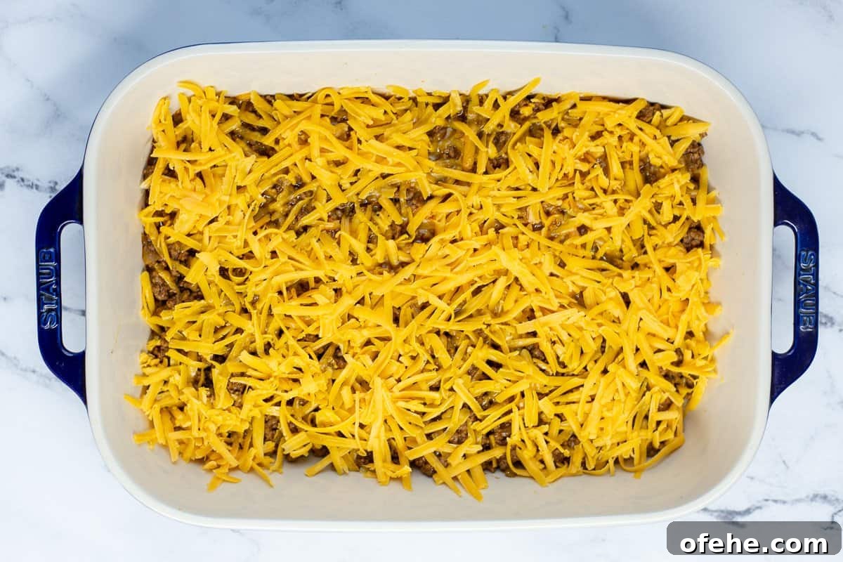Crunchy Frito Taco Casserole with Melted Cheese and Beef 6 Shredded cheese is added to the ground beef mixture in baking dish.
