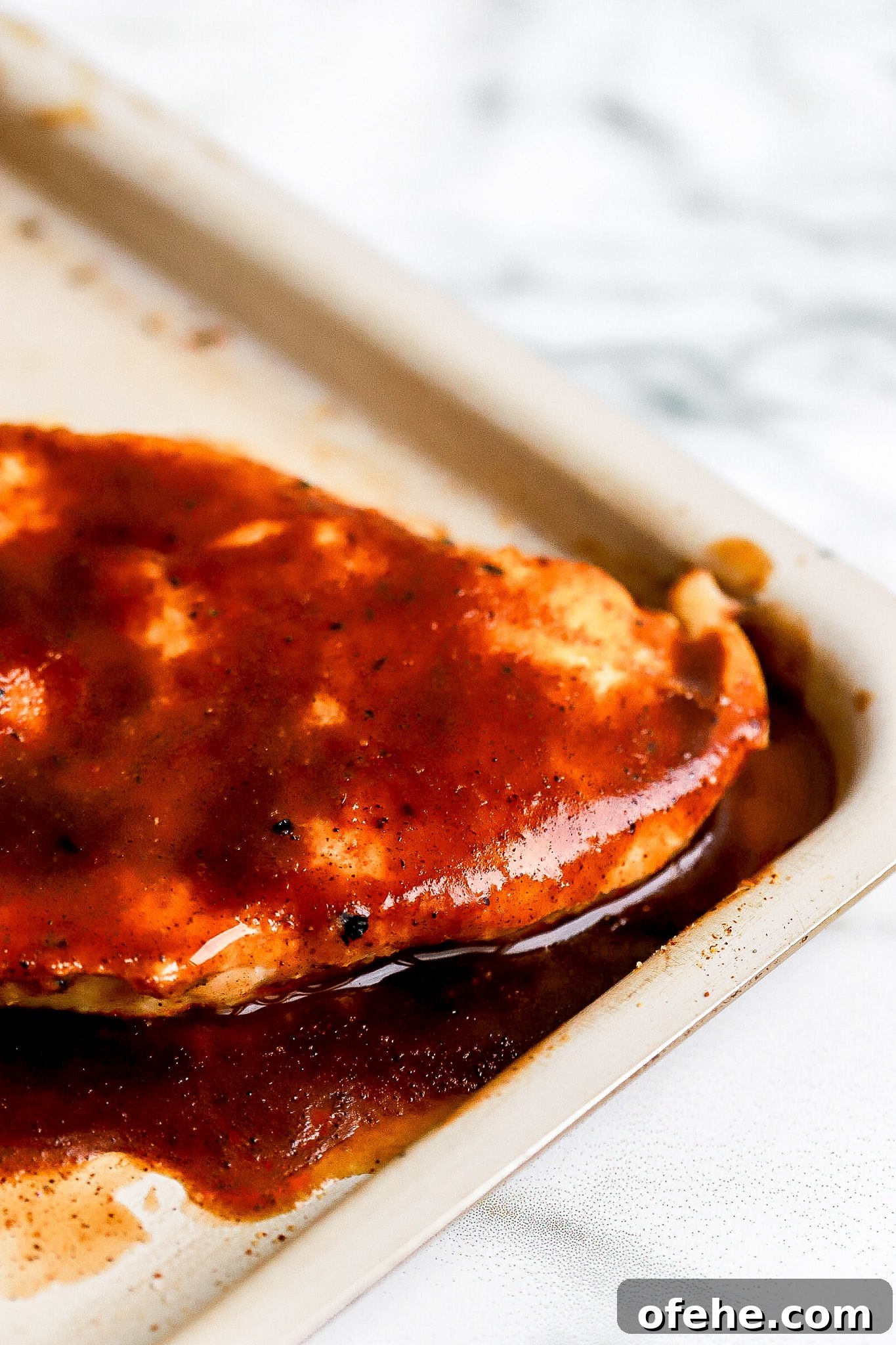 Air Fryer BBQ Chicken Breast — High-Protein 38g Recipe 3 Side angle of BBQ chicken breast in air fryer basket with sticky caramelized barbecue sauce