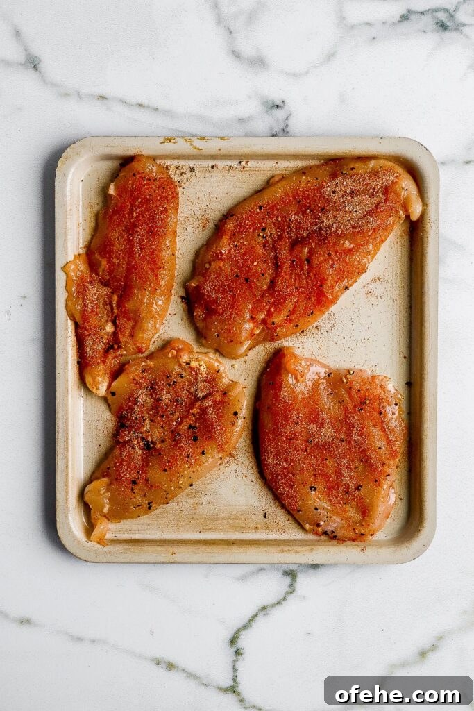 Air Fryer BBQ Chicken Breast — High-Protein 38g Recipe 4 Raw chicken breasts with dry rub seasoning on air fryer tray before cooking at 400°F