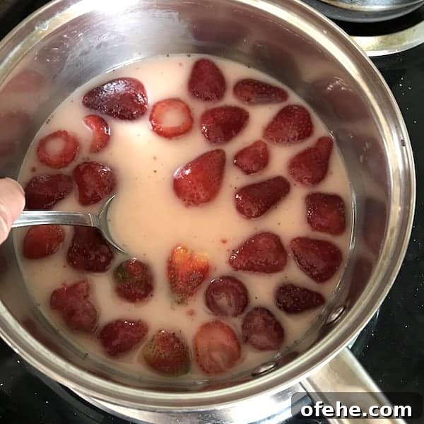 Homemade Strawberry Syrup Recipe for Pancakes & Drinks 3 Image shows a pot of strawberries boiling to make syrup