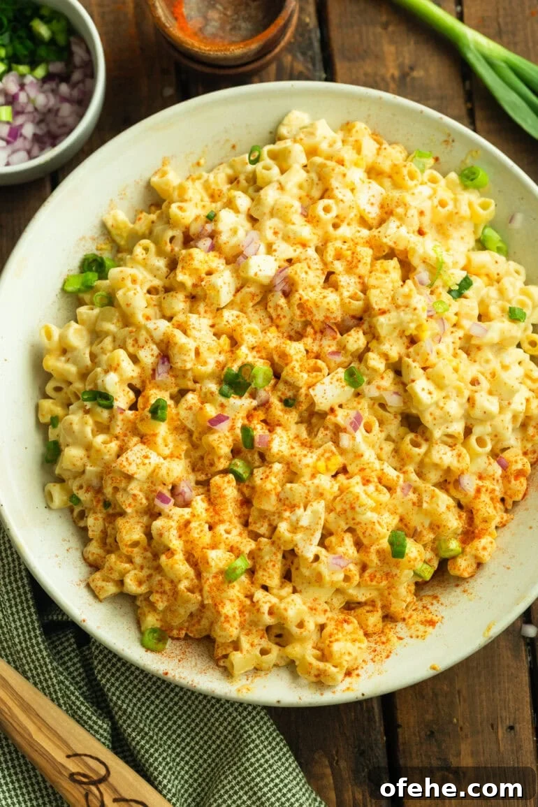 Deviled Egg Pasta Salad for Summer Gatherings 2 a photo of a large serving bowl of creamy deviled egg pasta salad topped with chopped chives