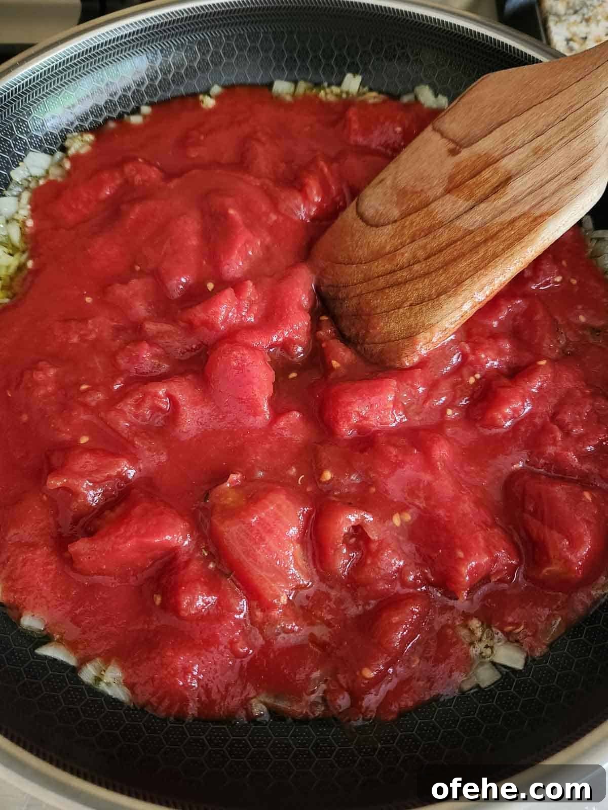 Poached Eggs in Spicy Tomato Sauce (Eggs in Purgatory) 5 Adding tomatoes to the skillet.