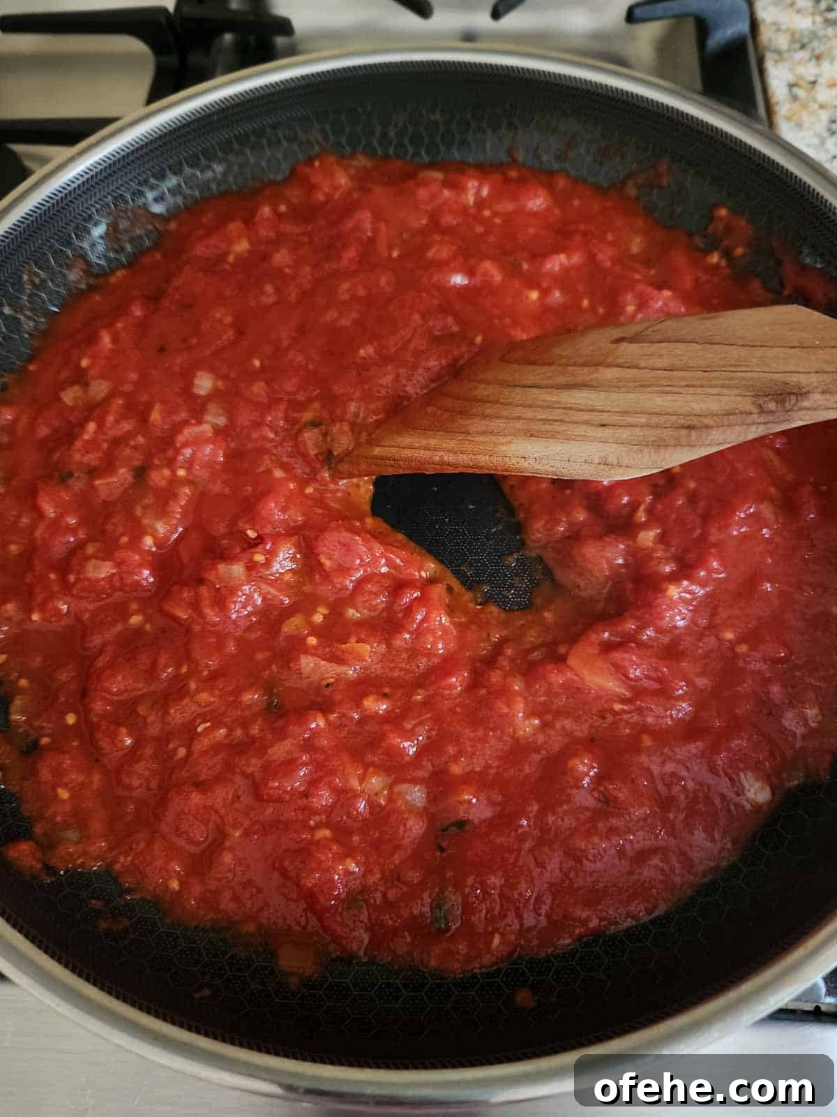 Poached Eggs in Spicy Tomato Sauce (Eggs in Purgatory) 7 Testing the thickness of the tomato sauce.