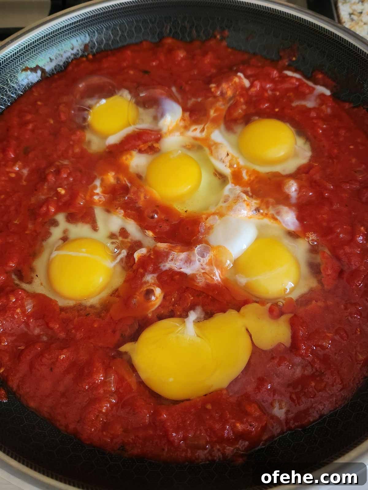 Poached Eggs in Spicy Tomato Sauce (Eggs in Purgatory) 8 Making wells in the sauce for eggs.