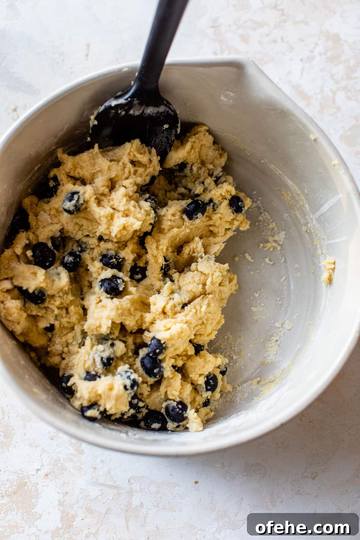 batter in a mixing bowl with fresh blueberries