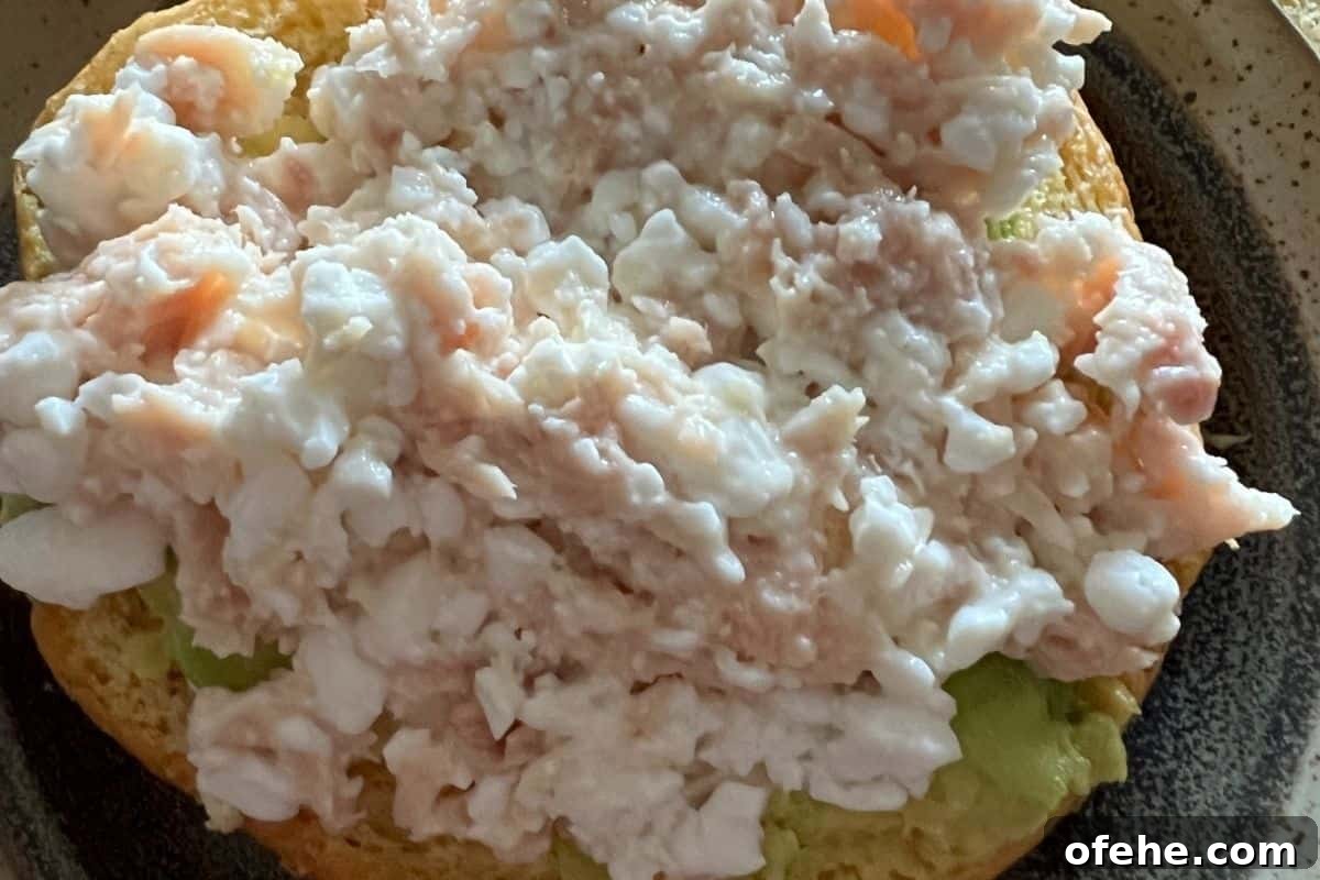 High-Protein Tuna and Cottage Cheese Recipes for Muscle Gain 4 Cottage cheese and tuna mixed together on a sandwich bun.