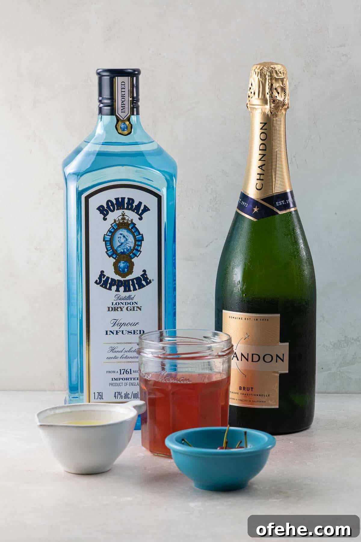 Sour Cherry French 75 Cocktail for Seasonal Entertaining 3 a bottle of sapphire gin, a bottle of chandon sparkling wine, sour cherry syrup, lemon juice, and cherries