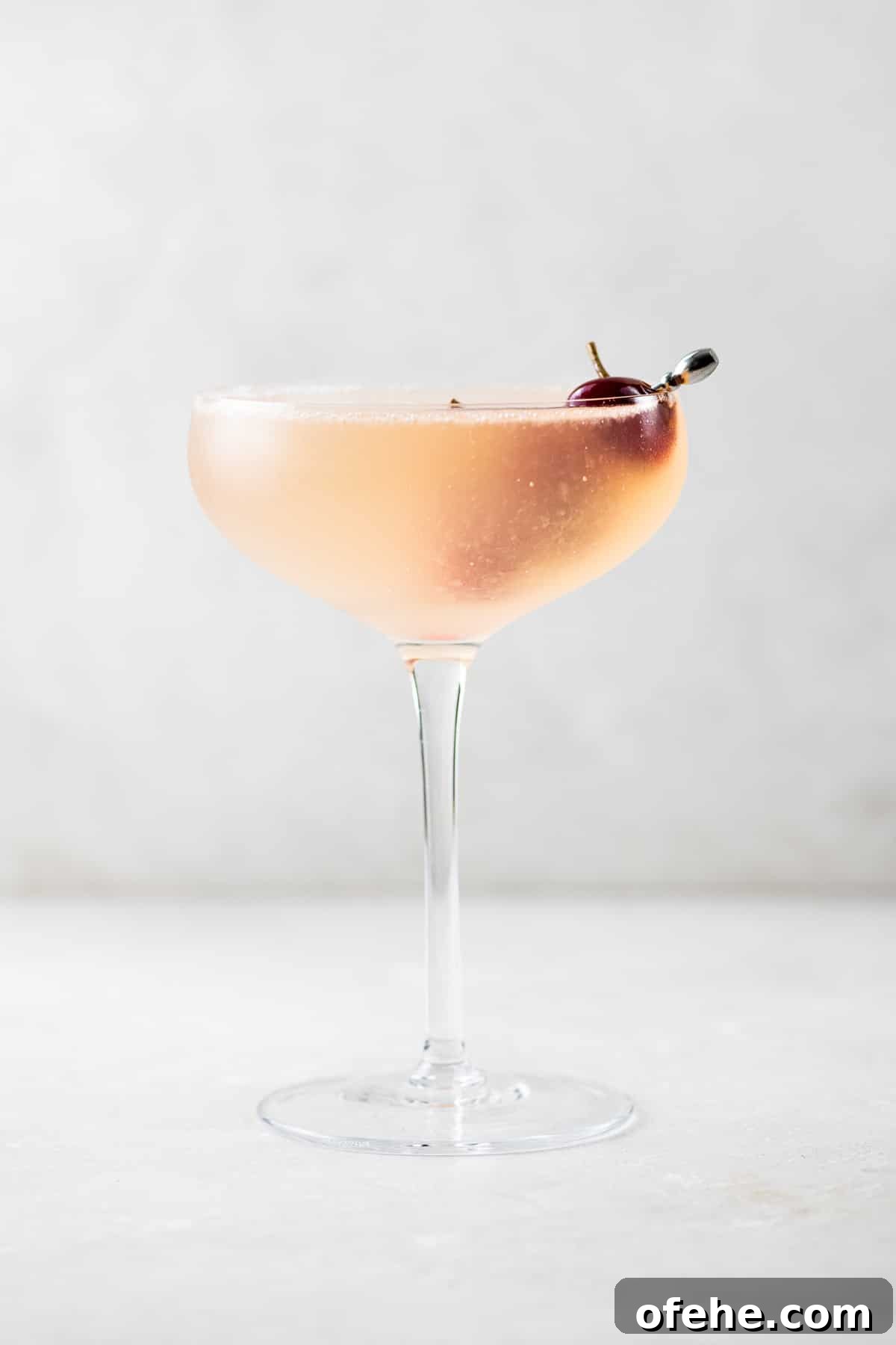 Sour Cherry French 75 Cocktail for Seasonal Entertaining 6 French 75 Sour Cherry Cocktail in a coupe glass garnished with homemade maraschino cherries