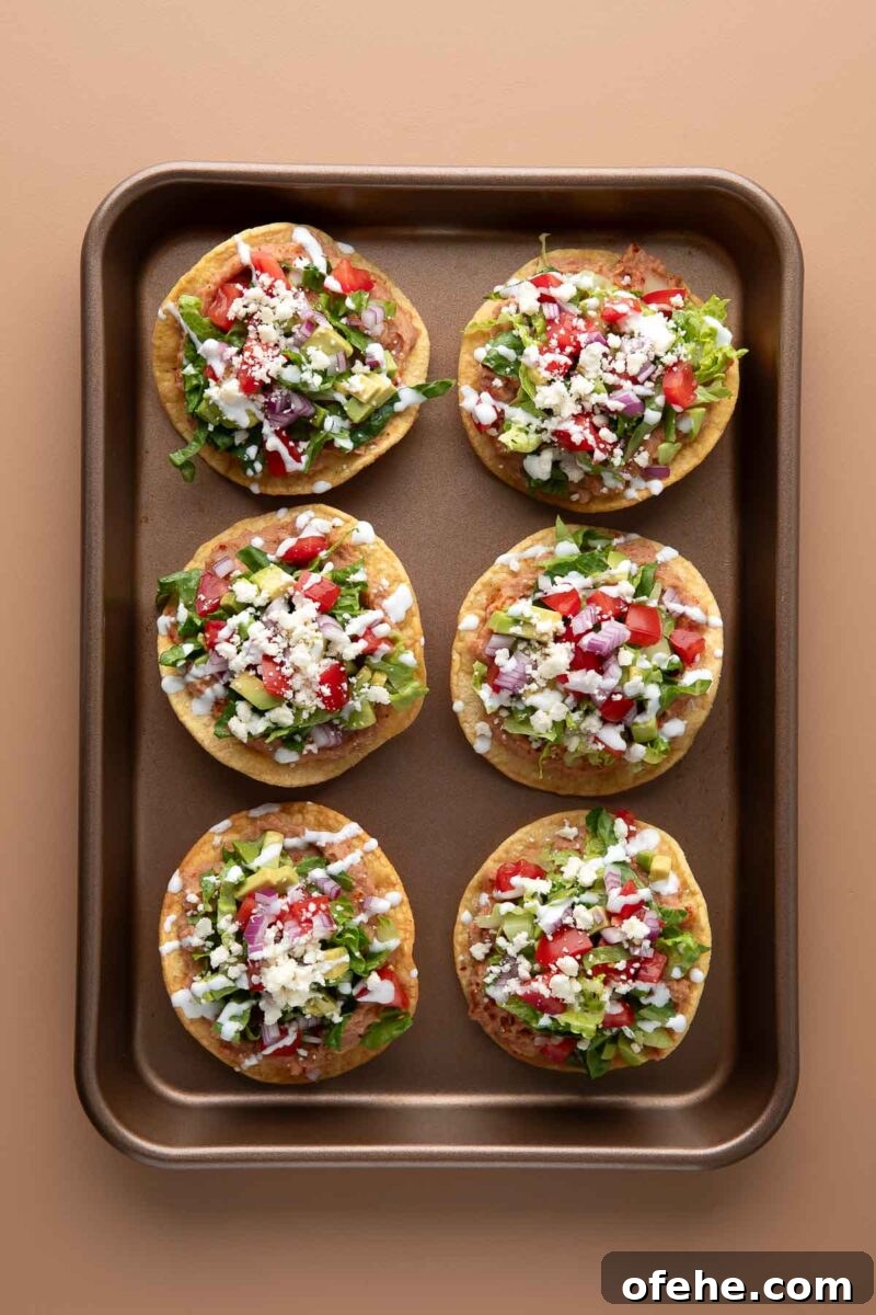 Crispy Mini Tostadas: Party-Ready Bite-Sized Tacos 6 mini tostada shells topped with beans, lettuce, tomato, avocado, red onion, cheese, sour cream, and green onions