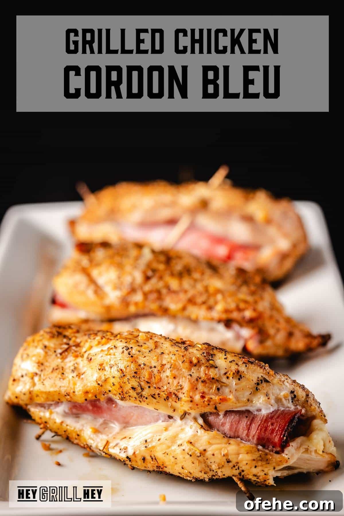 Crispy Grilled Chicken Cordon Bleu Recipe with Ham & Melty Cheese 2 Grilled chicken cordon bleu cutlets on white plate. Text reads "Grilled Chicken Cordon Bleu".
