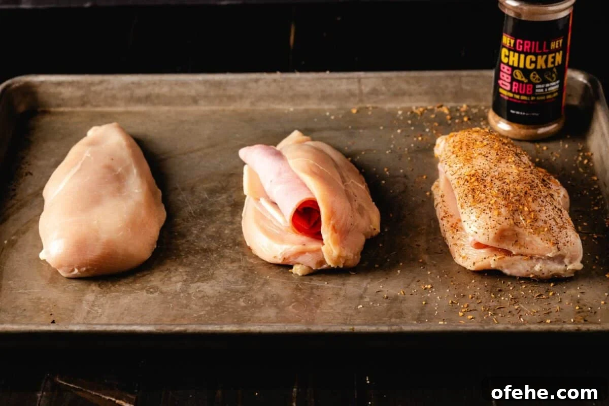 Crispy Grilled Chicken Cordon Bleu Recipe with Ham & Melty Cheese 3 Raw, stuffed chicken breasts on baking sheet.