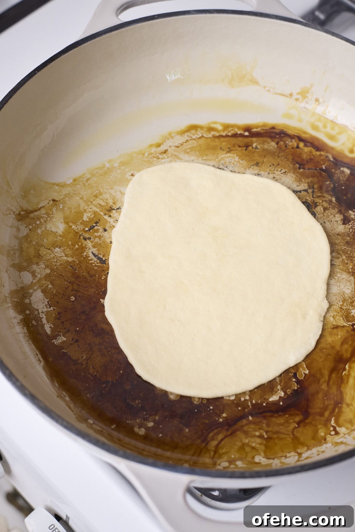 A tortilla cooking in a skillet.