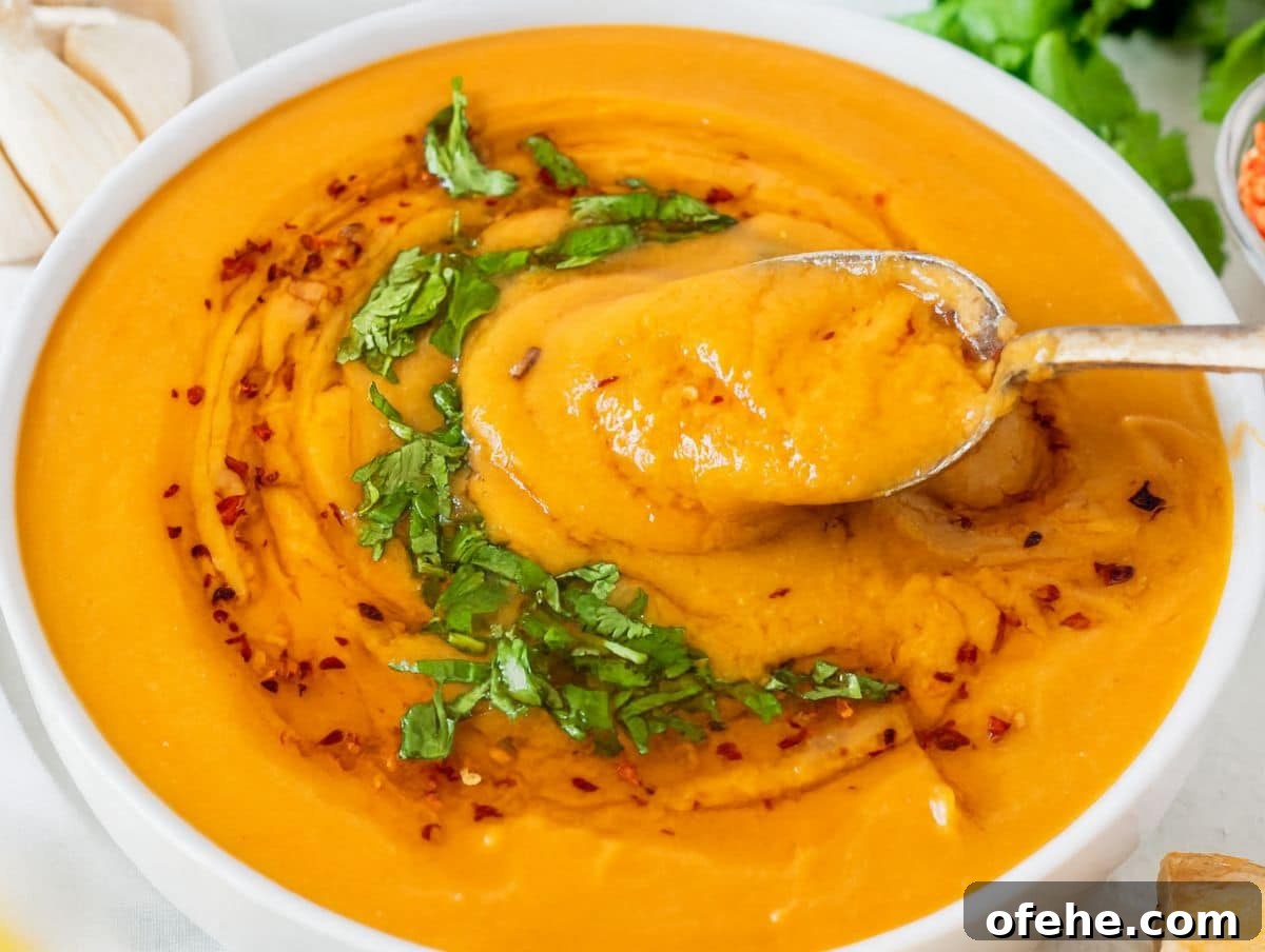 30-Minute Dinners We Cook on Busy Weeknights 23 Bowl of creamy lentil soup healthy and high protein with spoon and fresh parsley on a rustic table.