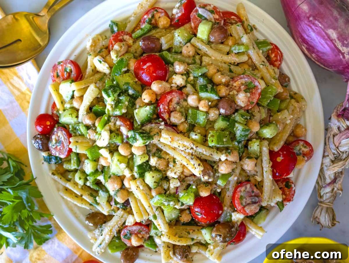30-Minute Dinners We Cook on Busy Weeknights 27 Step picture 4 Serving the Greek pasta salad on a white platter.