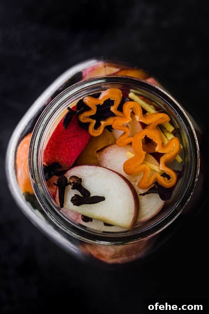 Quick Pickled Fruit: Perfect Brine Ratio for Every Batch 14 over head in process peach pickling shot! peaches in a jar with spices and other additions ready for the brine to be poured in.