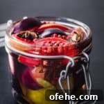 Quick Pickled Fruit: Perfect Brine Ratio for Every Batch 15 pickled plums! plums pickled with star anise, cinnamon, pink peppercorns and pickling brine in a jar, side angle on a black background.