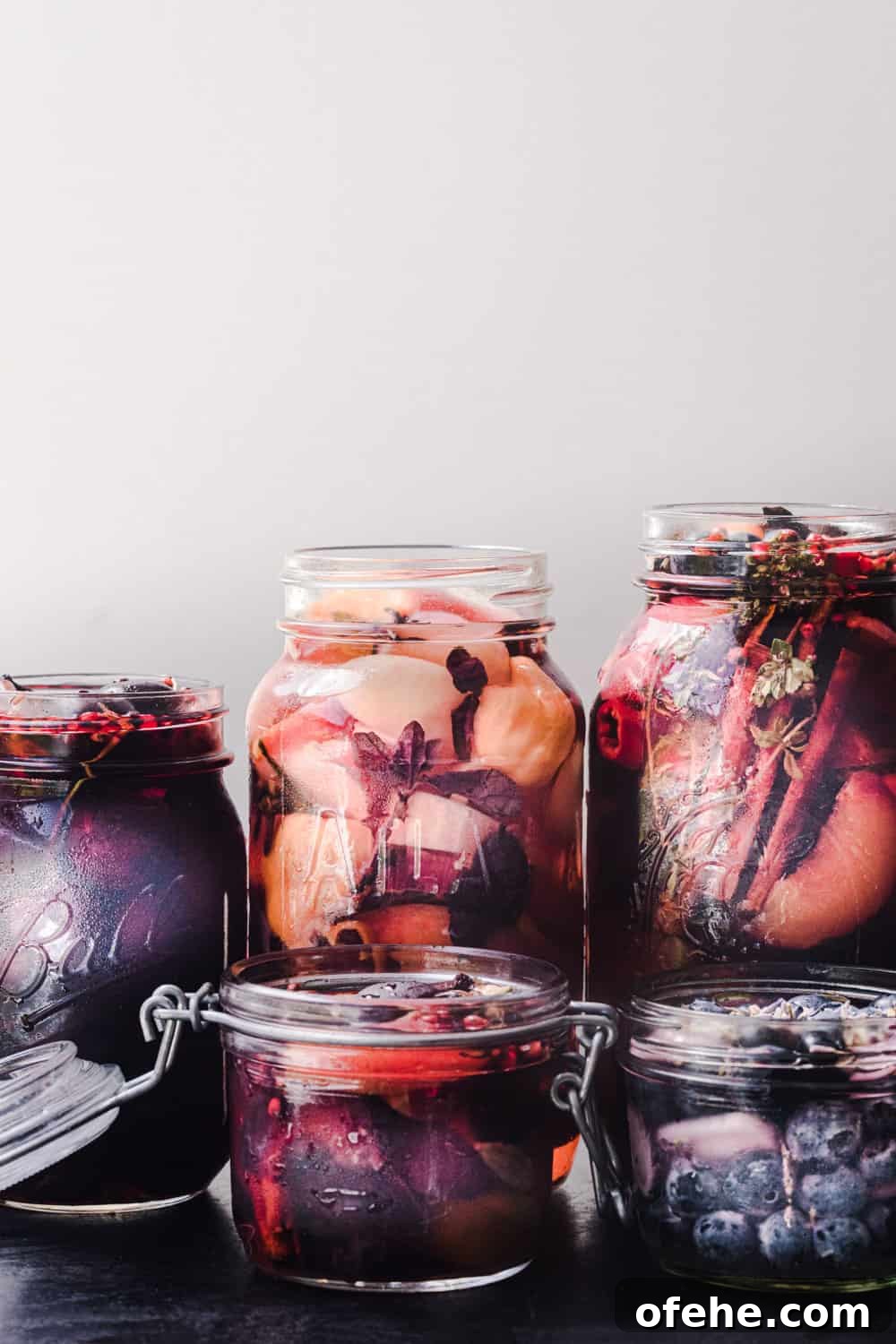 Quick Pickled Fruit: Perfect Brine Ratio for Every Batch 5 pickled summer fruit in jars! here's pickled peaches, pickled plums, pickled cherries, pickled blueberries, and mixed pickled fruit, shot straight on.
