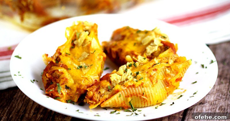 Taco Stuffed Shells Recipe is perfect for a family dinner night! A Mexican-inspired pasta dish, this Taco Stuffed Shells recipe mixes seasoned ground beef in a creamy, cheesy sauce to stuff in shells for a delicious meal. Two family favorites, combined into one!