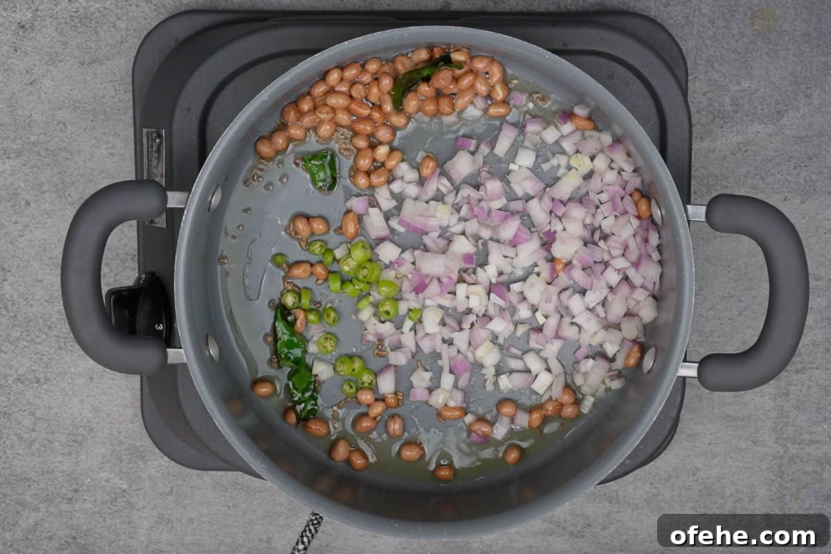 Millet Poha: Flavorful Wholesome Breakfast Recipe for Busy Mornings 8 Onions and green chilies added to the pan.