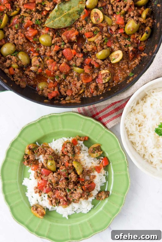 Authentic Brazilian Picadillo (Picadinho) Recipe for Dinner 2 Picadillo is served over rice in a bright green bowl next to a pan holding more picadillo and a bowl holding extra rice