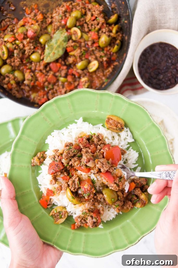 Authentic Brazilian Picadillo (Picadinho) Recipe for Dinner 12 A person holds a utensil in picadillo over rice inside a green bowl