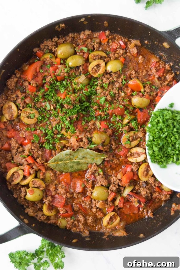 Authentic Brazilian Picadillo (Picadinho) Recipe for Dinner 9 Parsley is sprinkled on top of a Brazilian picadillo recipe in a braising pan from above