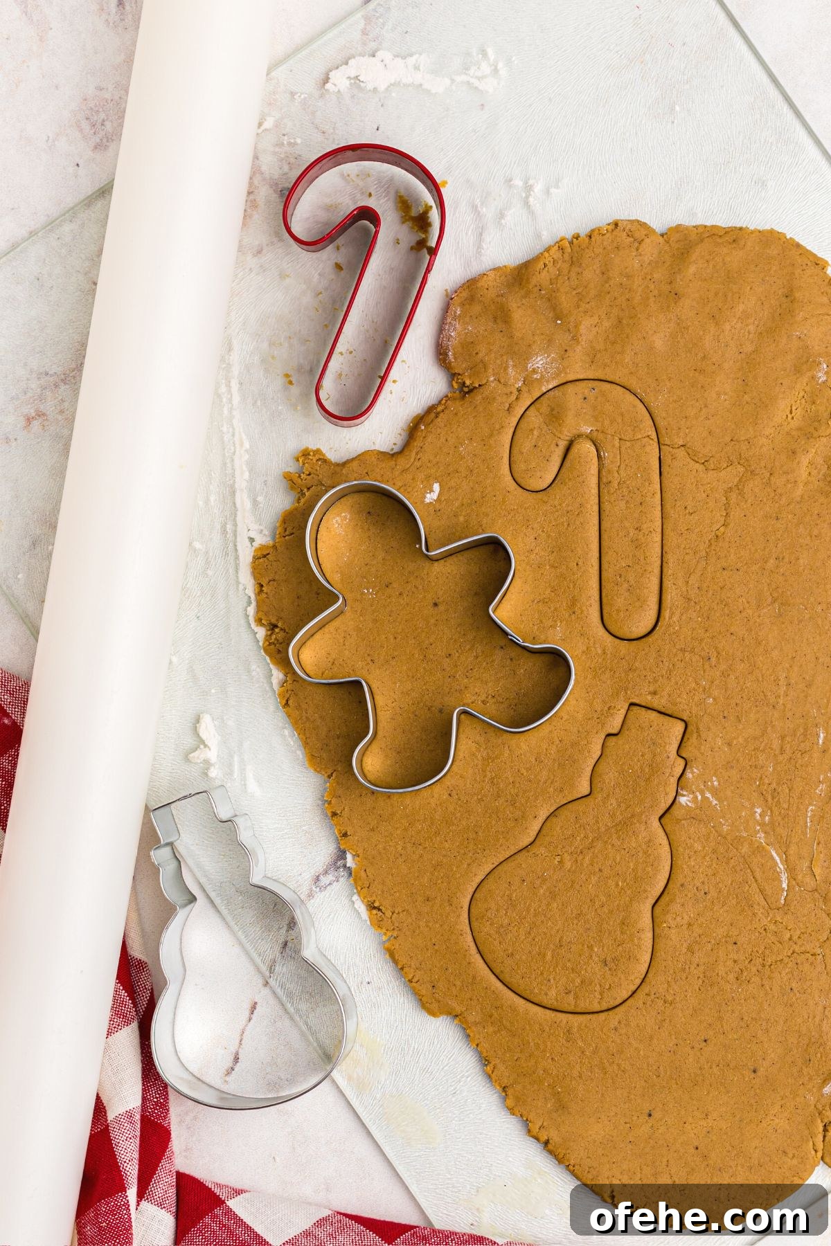 Chewy Air Fryer Gingerbread Cookies Recipe 8 Golden dough rolled out with a cookie cutters and a rolling pin on table