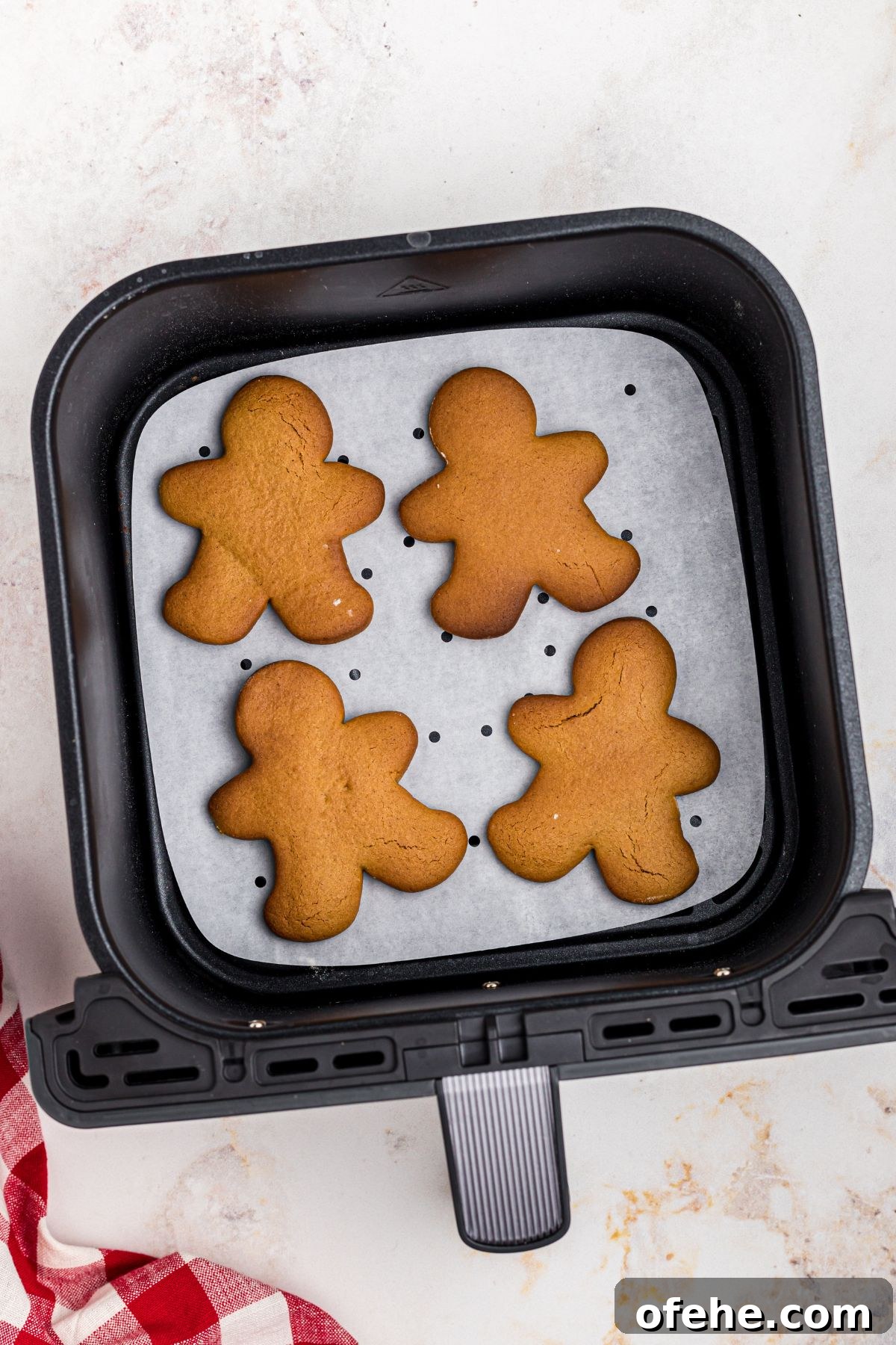 Chewy Air Fryer Gingerbread Cookies Recipe 10 Golden gingerbread men cookies in an air fryer basket after being cooked