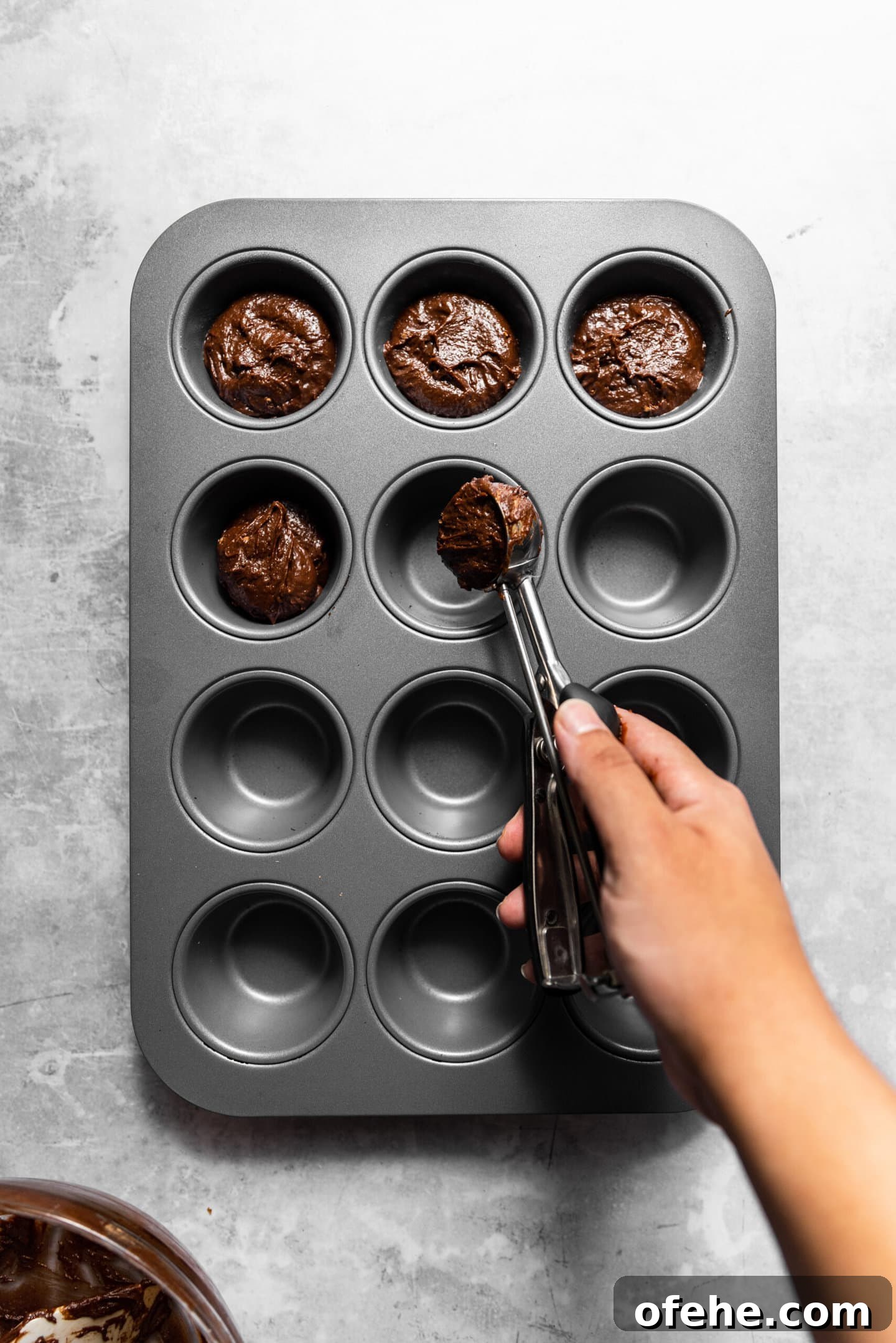 Salted Caramel Brownie Bites in a Muffin Tin 8 Brownie batter being scooped into muffin pan.