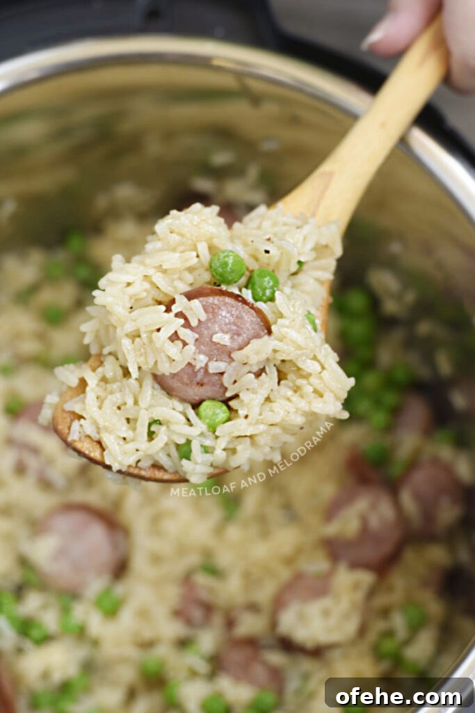Instant Pot Kielbasa with Savory Rice Bowl 5 Instant Pot kielbasa with jasmine rice and peas on a wooden spoon