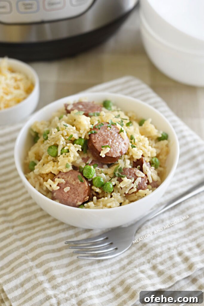 Instant Pot Kielbasa with Savory Rice Bowl 6 pressure cooker smoked sausage and rice with peas and cheese in a white bowl