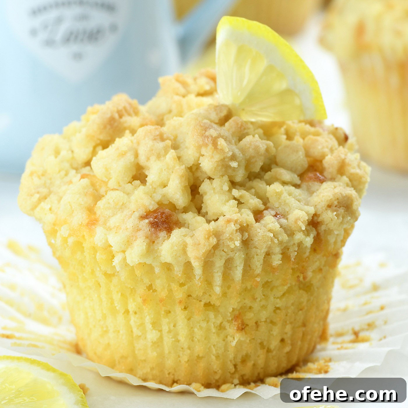bakery style lemon muffin with crumb topping and fresh lemon slice on top