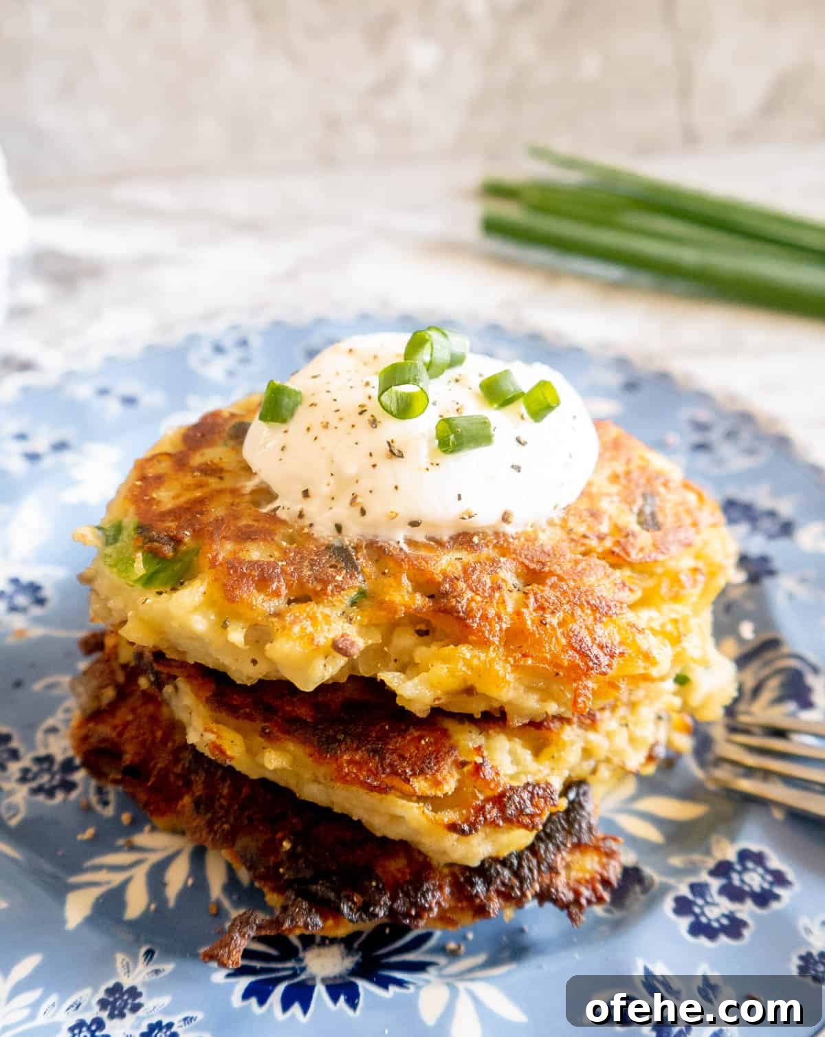 Gluten-Free Potato Pancakes with Optional Whole30 Version 2 Gluten free potato pancakes on a plate with greek yogurt on top.