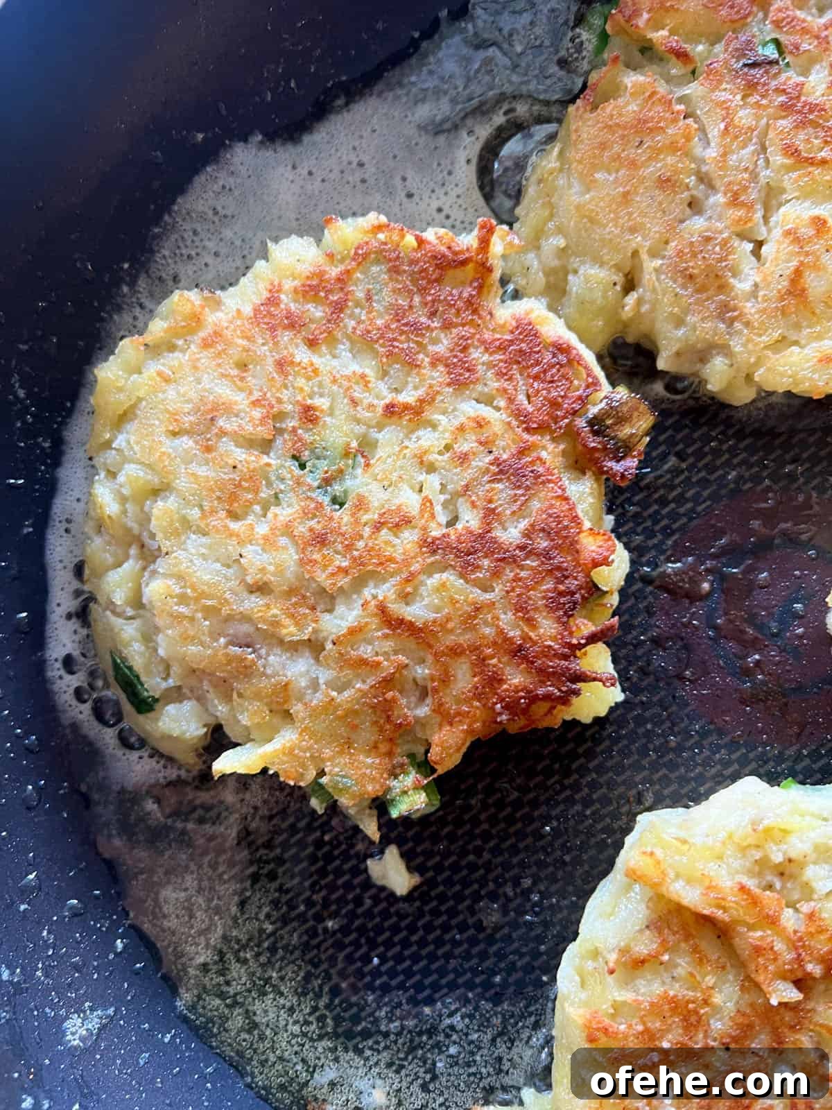 Gluten-Free Potato Pancakes with Optional Whole30 Version 13 Potato pancakes cooked on a pan.