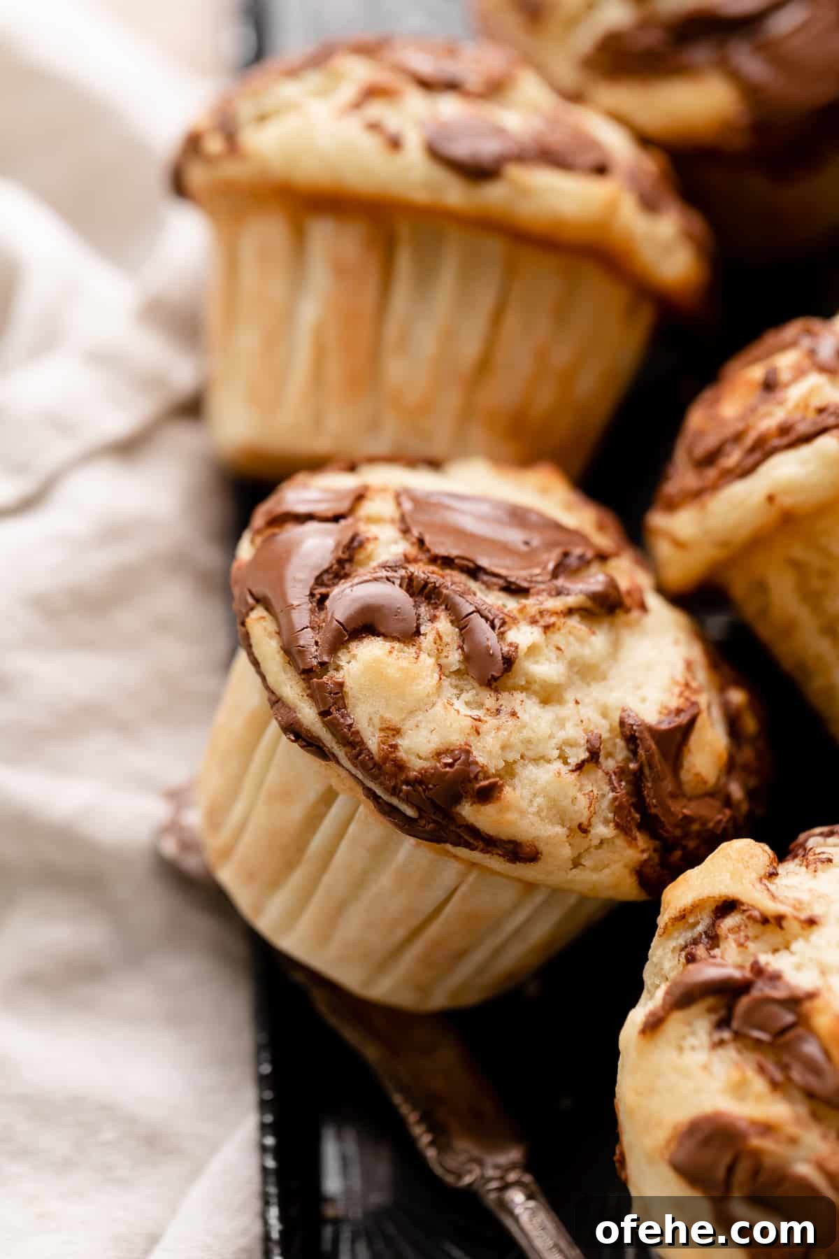 Chocolate Hazelnut Banana Muffins — Moist & Gooey Recipe 2 nutella banana muffin with swirled nutella on top.