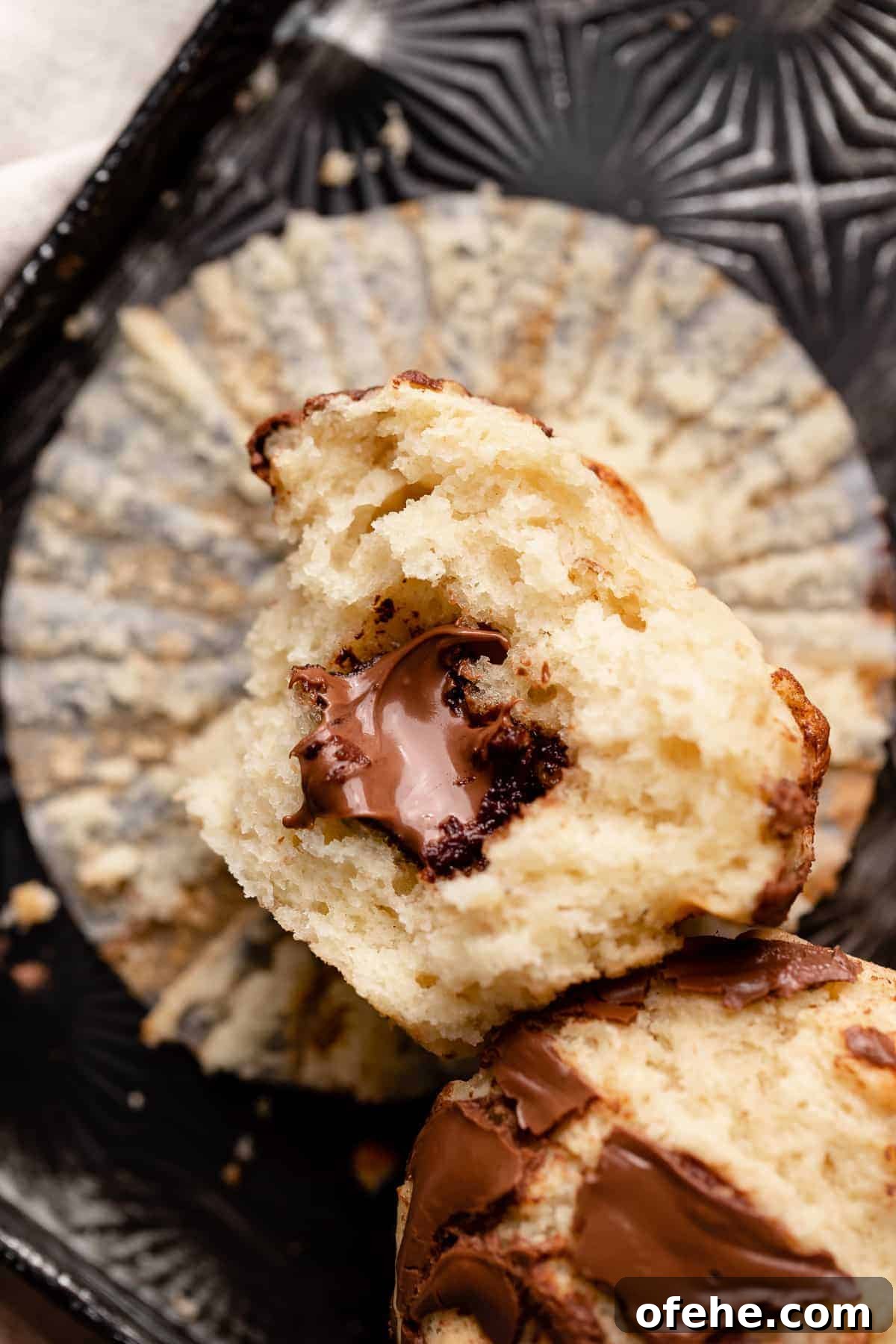Chocolate Hazelnut Banana Muffins — Moist & Gooey Recipe 10 a nutella muffin cut in half to show the gooey chocolate hazelnut spread in the center.