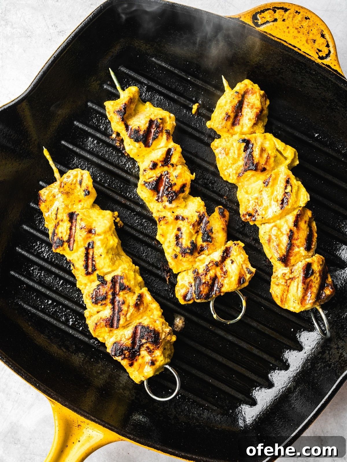 Persian Saffron Joojeh Kabob Recipe — Grilled Chicken Kabab 8 Persian saffron chicken skewers grilling on an indoor grill pan.