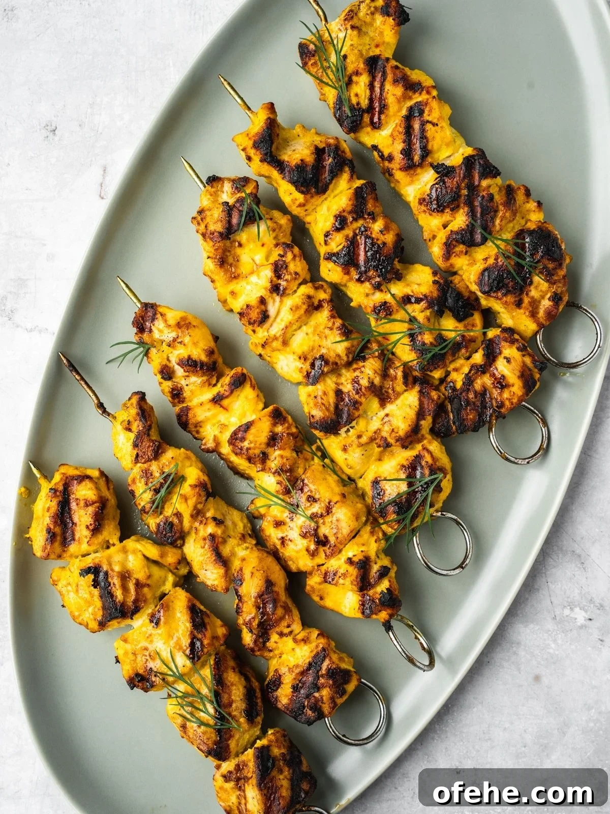 Persian Saffron Joojeh Kabob Recipe — Grilled Chicken Kabab 9 Grilled Joojeh Kabob chicken skewers with a golden char on an oval platter.