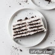 No-Bake Icebox Cake Recipe for Creamy Layered Dessert 4 A slice of icebox cake on a white plate with Oreo crumbs.