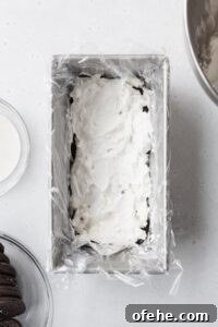 No-Bake Icebox Cake Recipe for Creamy Layered Dessert 6 A layer of cream in a loaf pan.