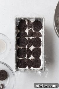 No-Bake Icebox Cake Recipe for Creamy Layered Dessert 7 Chocolate cookies on top of cream to build an icebox cake.