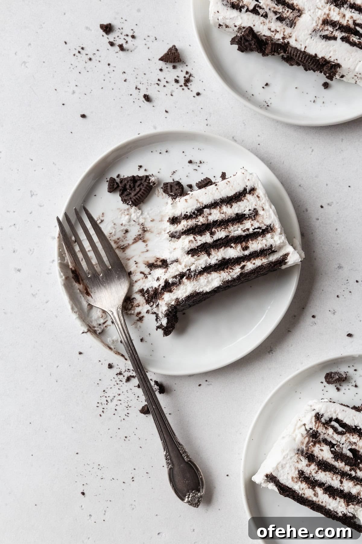No-Bake Icebox Cake Recipe for Creamy Layered Dessert 9 A partially eaten slice of icebox cake on a white plate with a fork.
