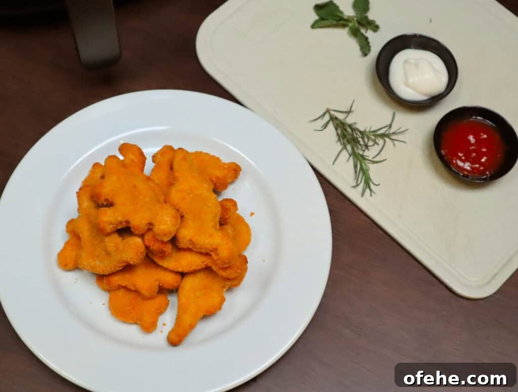 Crispy Dino Nuggets in the Air Fryer: Quick Family Snack 4 Dino nuggets on white plate