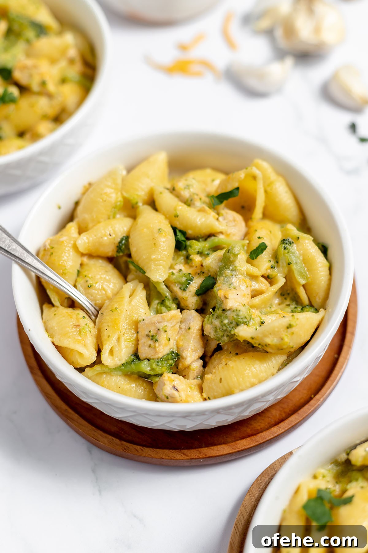 Chicken broccoli pasta served in a white bowl.