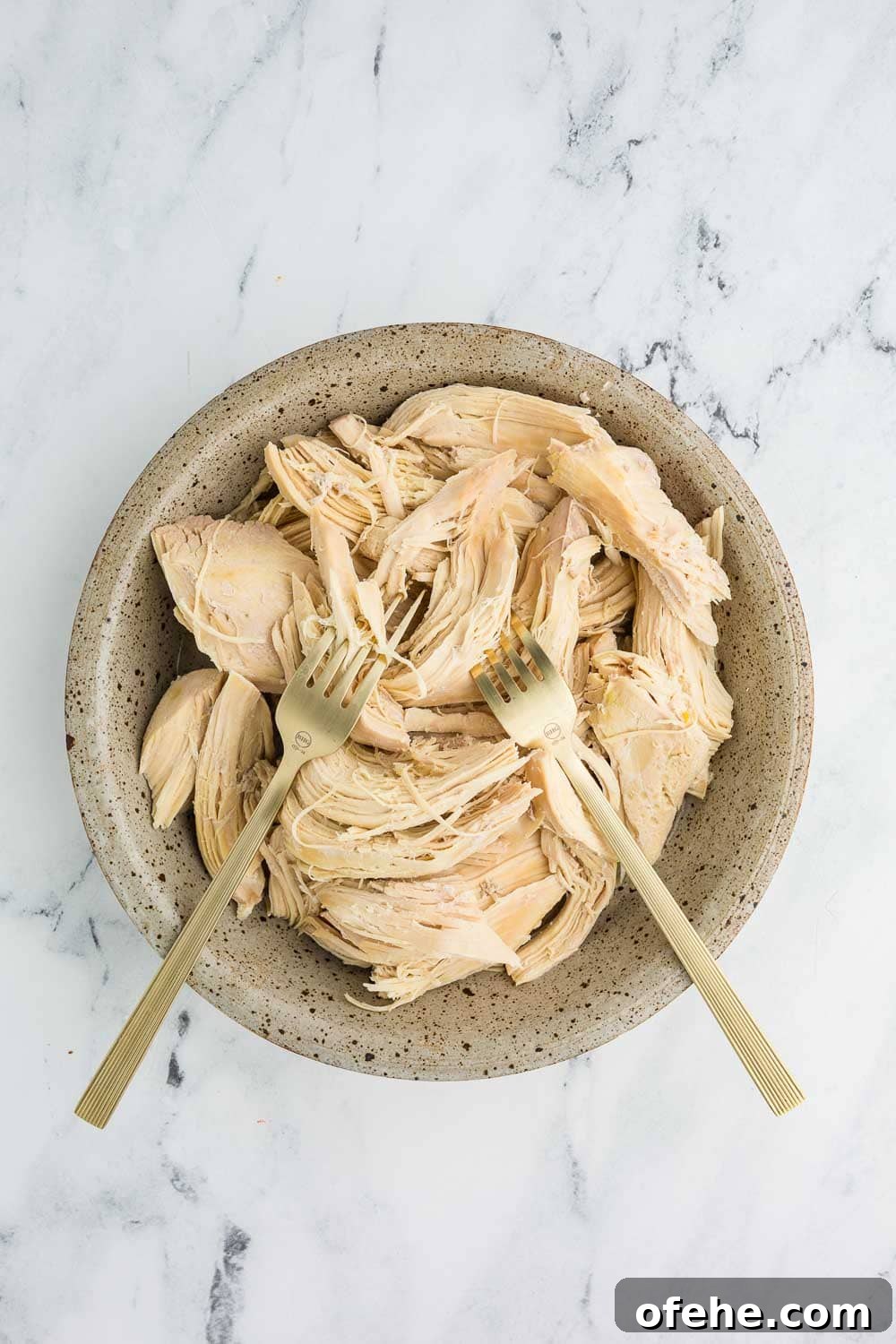 Slow Cooker Shredded Chicken Recipe for Tender, Juicy Meat 5 Slow cooker shredded chicken in bowl and 2 forks used to shred left in chicken