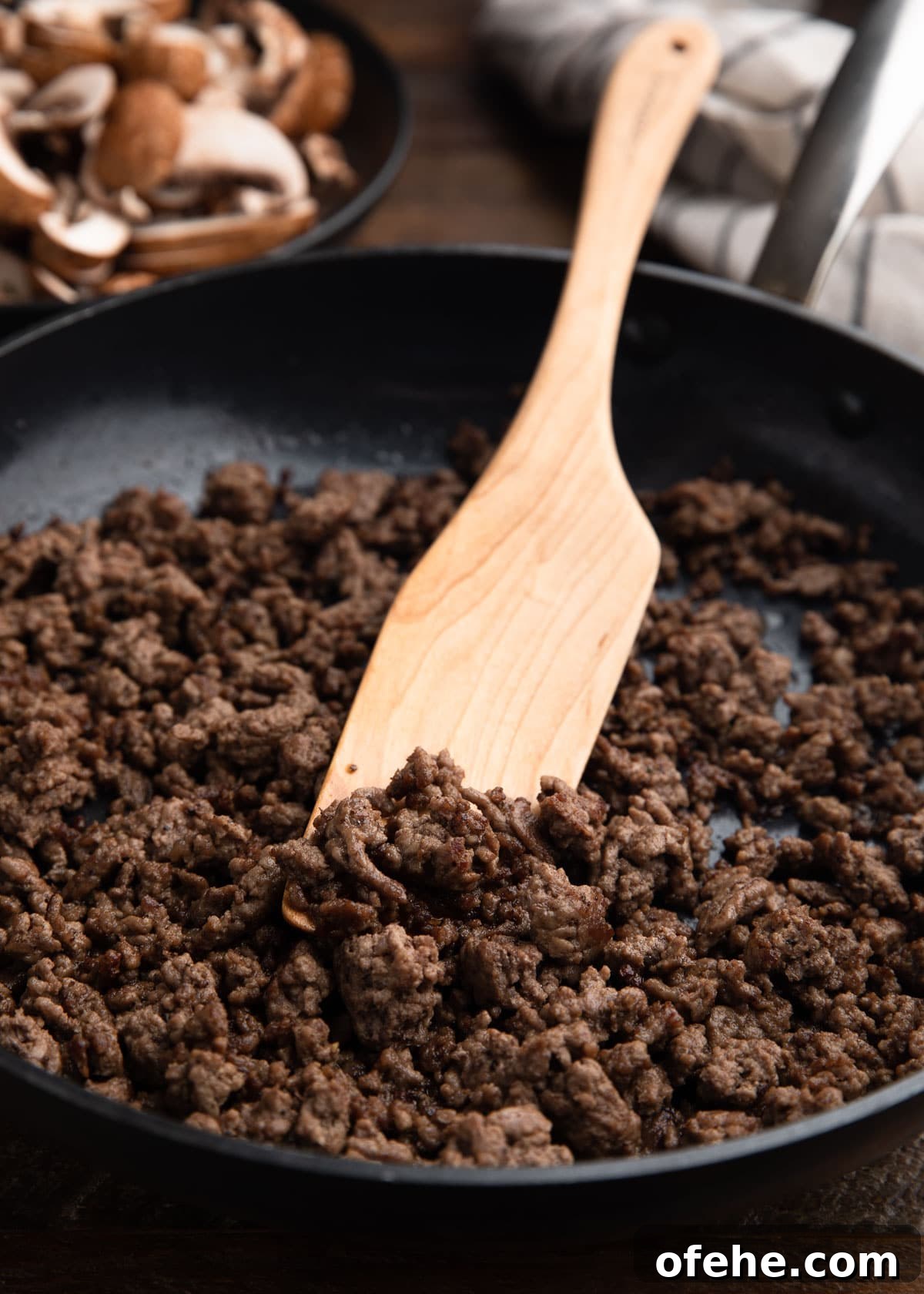 One-Pan Creamy Ground Beef Stroganoff Recipe 3 sautéed ground beef in a skillet with a wooden paddle