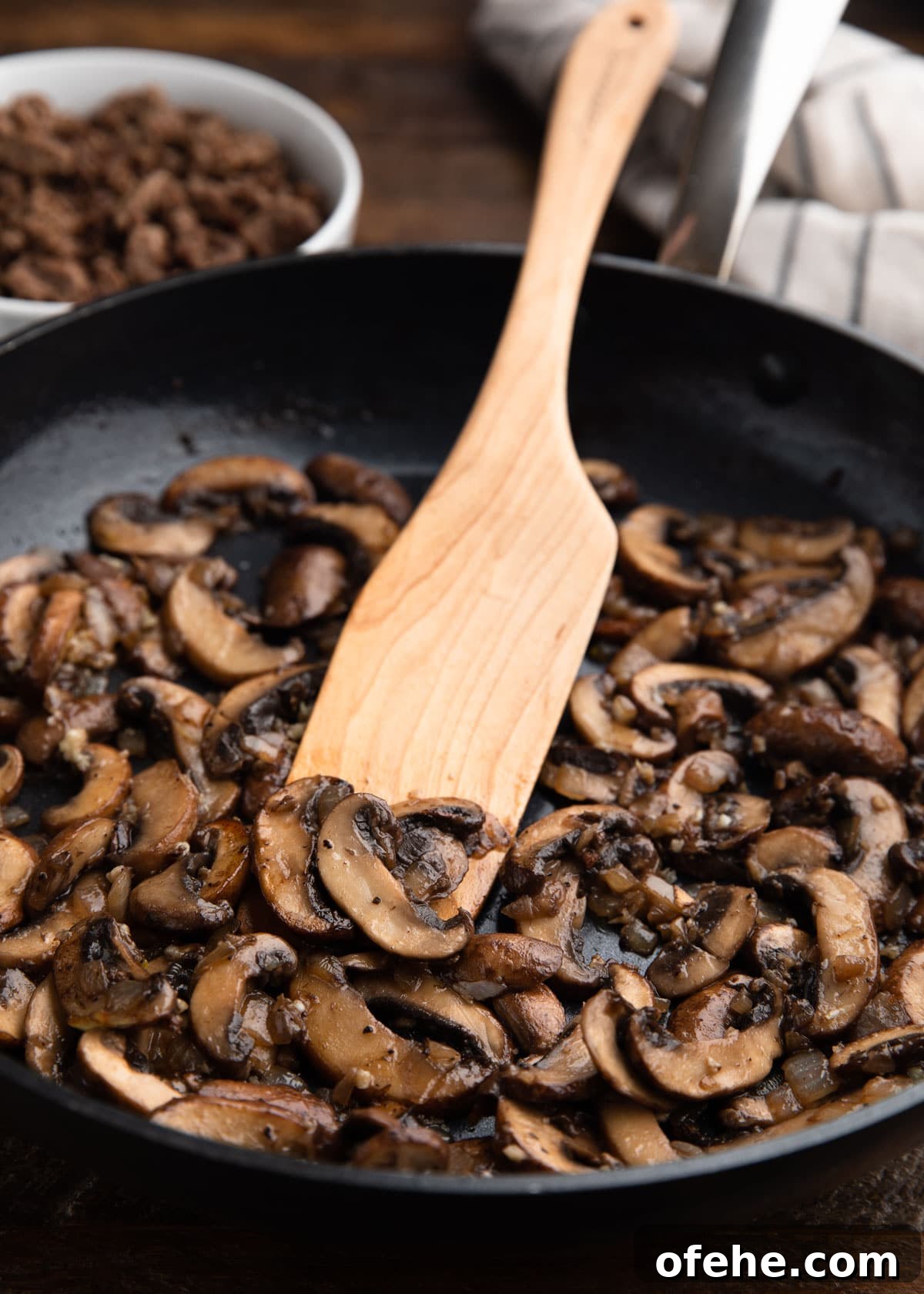 One-Pan Creamy Ground Beef Stroganoff Recipe 4 sauteed mushrooms in a nonstick skillet with a wooden spoon