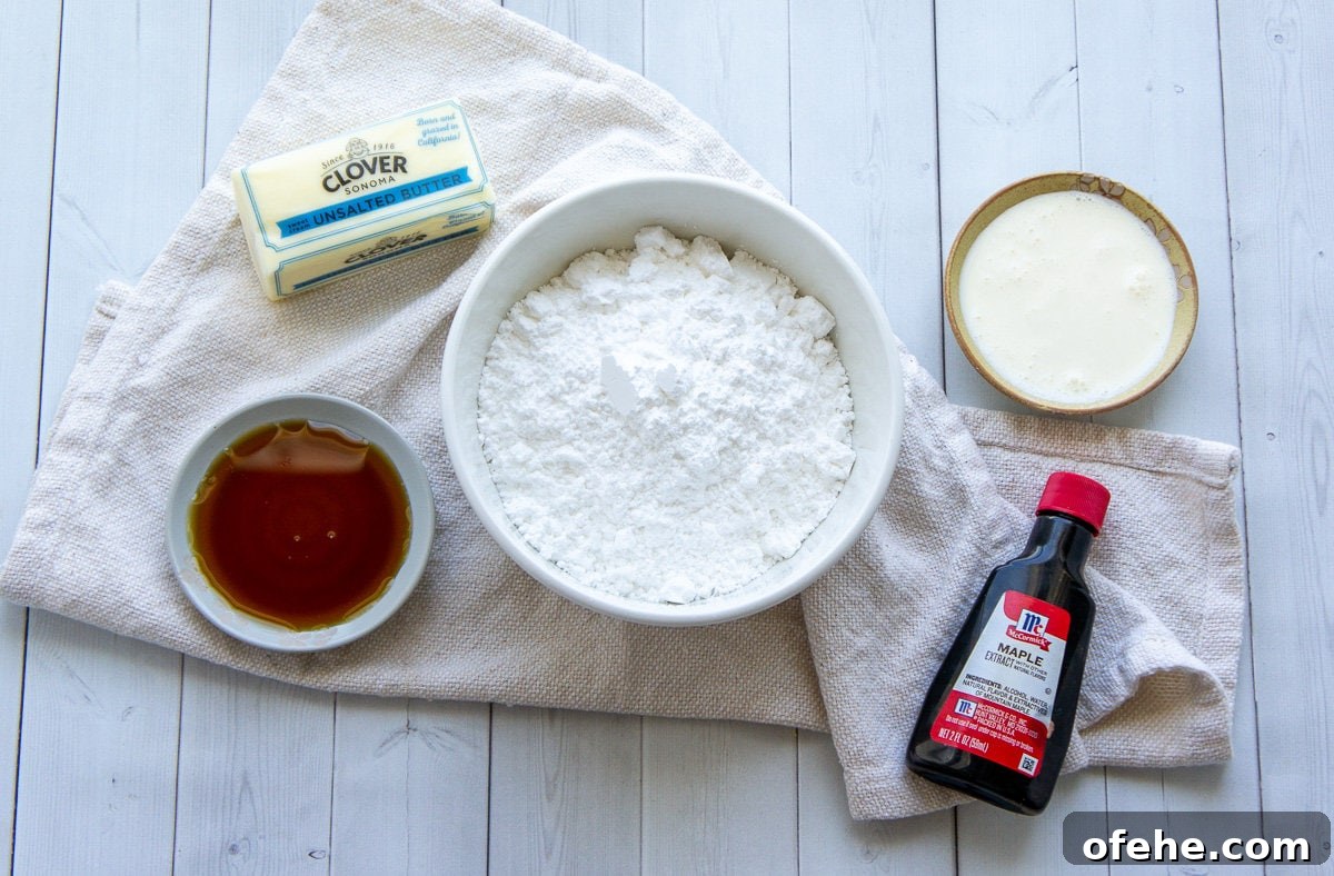 ingredients for maple buttercream including powdered sugar, maple syrup, extract, whipping cream, and butter.